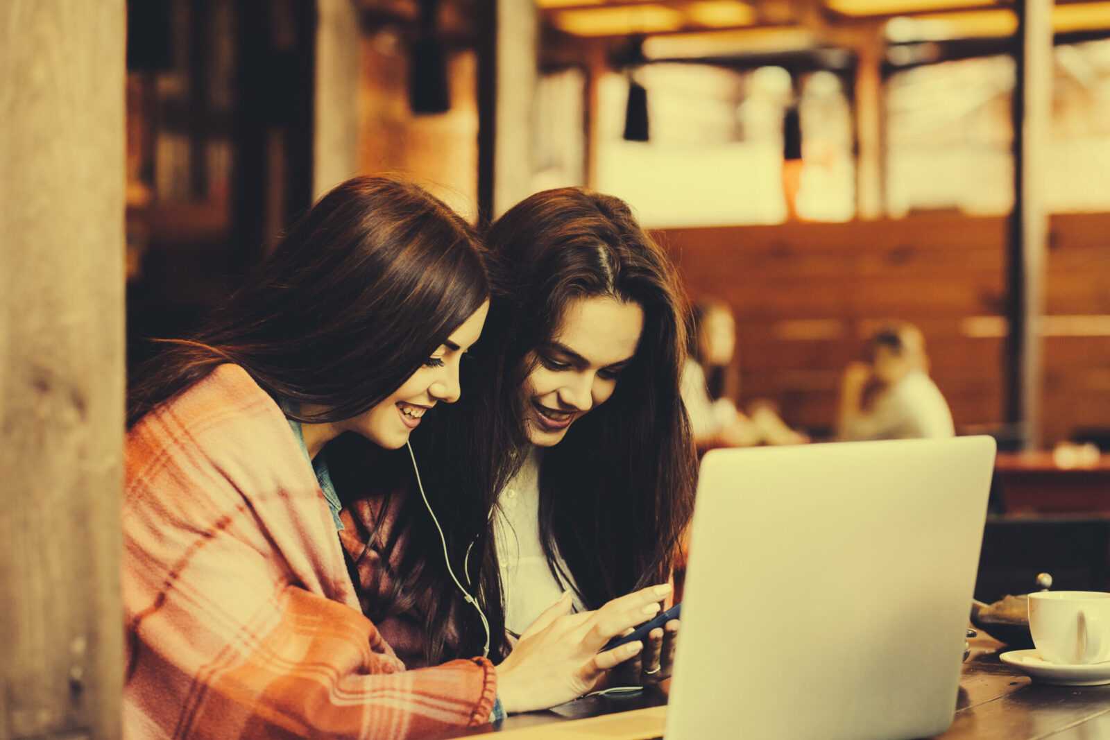two girls watching something in laptop