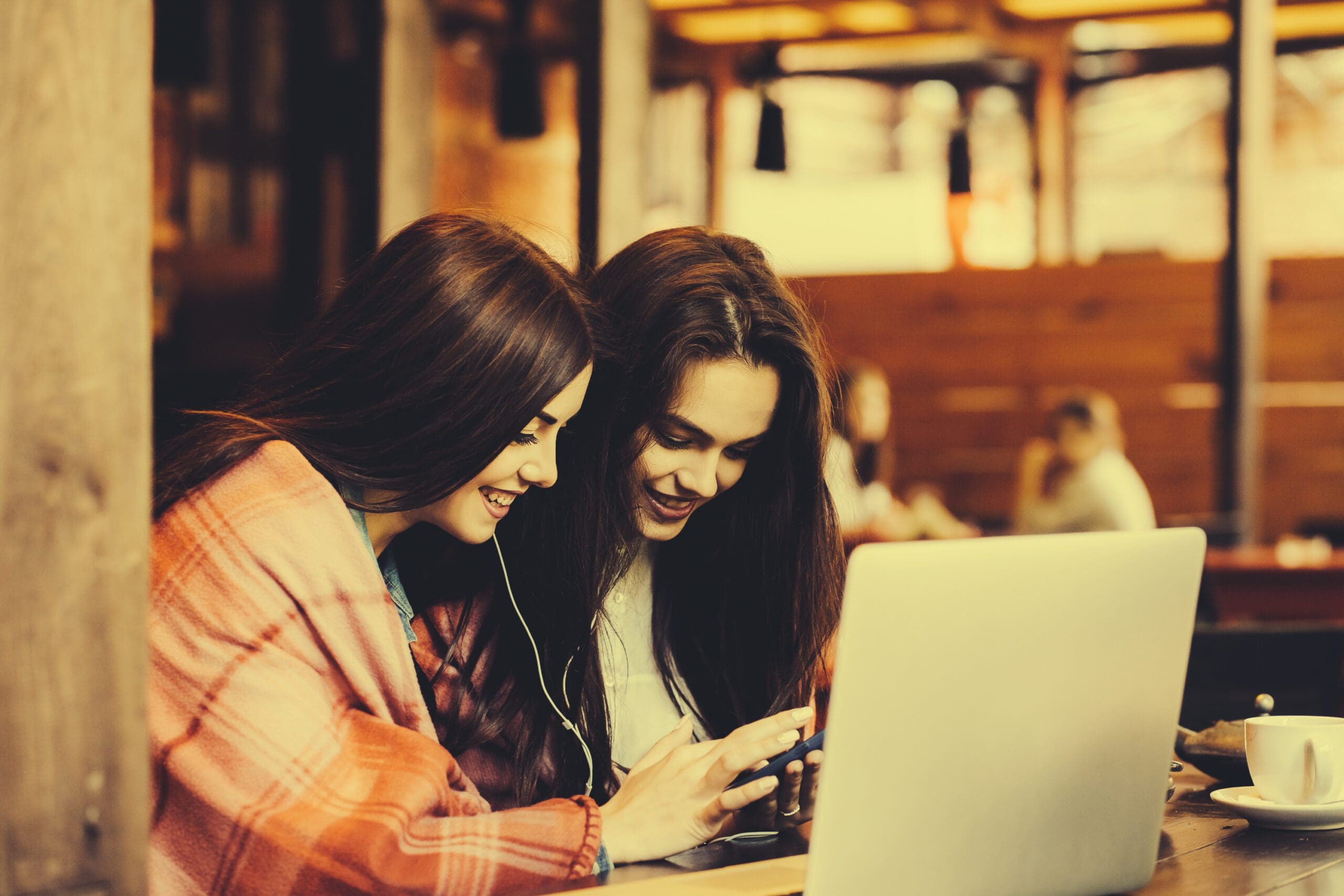 two girls watching something in laptop